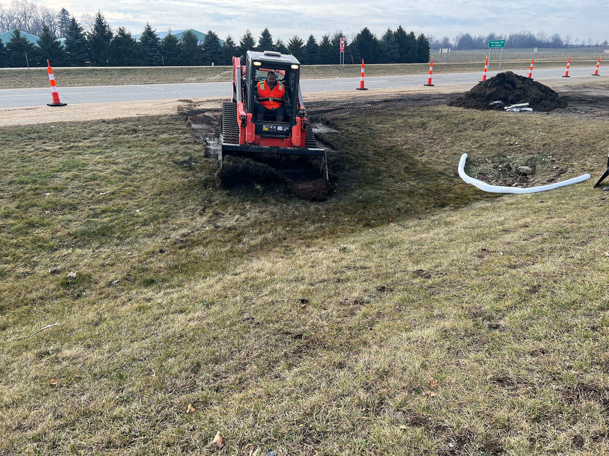 Tracked skid steer with a large winch box on the front for towing and recovery.