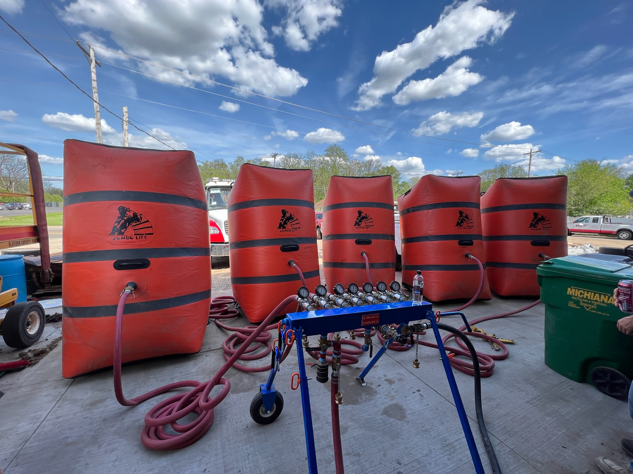 A large tractor trailer hauling a low boy trailer with a large piece of machinery on it.